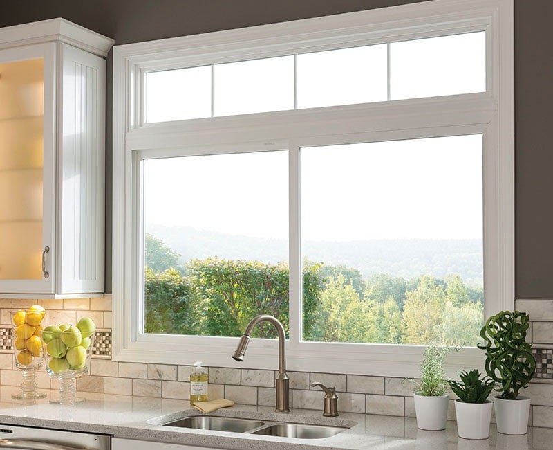 White slider window overlooking wooded area